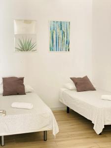 セビリアにあるFlamenca Triana - Apartamento Totalmente Equipado Wifi 2D sofas camas 2 bañosのベッド2台が隣同士に設置された部屋です。