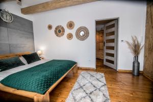 a bedroom with a bed with a green comforter at AP Apartment's in Wałbrzych
