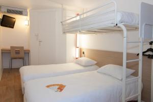 two beds in a room with two bunk beds at Premiere Classe Saint Malo St Jouan Des Guerets in Saint-Jouan-des-Guérets