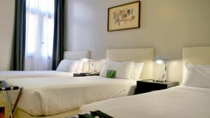 una habitación de hotel con 2 camas y una lámpara en 562 Nogaro en Buenos Aires