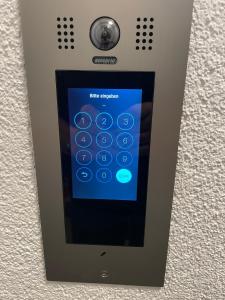 a gray remote control with a blue screen at Apartment-Haus Landeskrone in Dresden