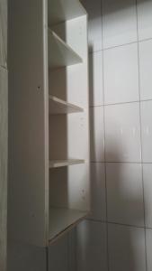 um armário branco com prateleiras vazias num quarto em Hostel Meu Sossego Vilas em Lauro de Freitas