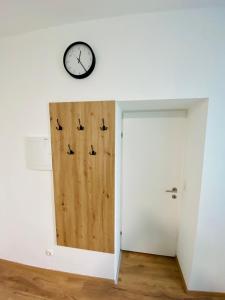 um quarto com uma porta e um relógio na parede em Einzimmer-Apartment 25 m2 Gartenzinken im Zentrum von Bad Ischl em Bad Ischl
