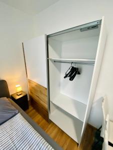 a glass refrigerator in a bedroom with a bed at Einzimmer-Apartment 25 m2 Gartenzinken im Zentrum von Bad Ischl in Bad Ischl