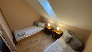 an attic room with two beds and two candles on tables at Penzion Florian in Moldava