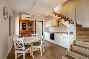 una cocina con mesa y sillas y una escalera en Villa Peroni Lake Como Cottage with swimming pool en Argegno
