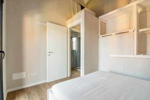 1 dormitorio con cama blanca y puerta de entrada en Villa Peroni Lake Como Cottage with swimming pool en Argegno