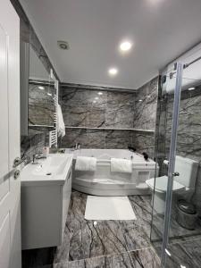 a bathroom with a tub and a sink at Suite In City Center in Tirana