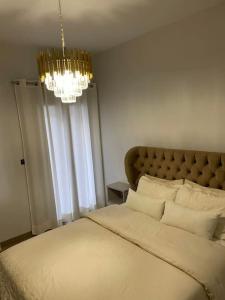 a bedroom with a large bed and a chandelier at October Luxury Apartments Studio in Ioannina
