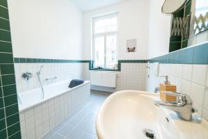 a bathroom with a tub and a sink and a bath tub at FullHouse - Halle - VS7 - 3 Beds - Nespresso in Halle an der Saale
