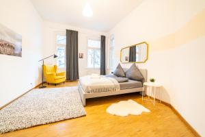 ein Wohnzimmer mit einem Sofa und einem gelben Stuhl in der Unterkunft FULL HOUSE Premium Apartments Halle VS7 in Halle an der Saale