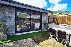 a patio with a table and chairs and grass at Coastal Heaven Downings in Downings