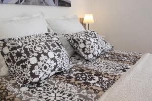 a bed with black and white pillows on it at FLORIT FLATS - The Ausias March Apartment in Valencia