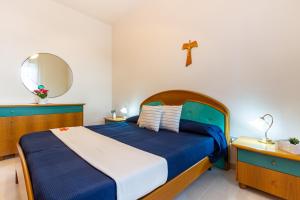 una camera con un letto blu e una croce sul muro di Appartamento Orchidea A1 - MyHo Casa a Torre Canne