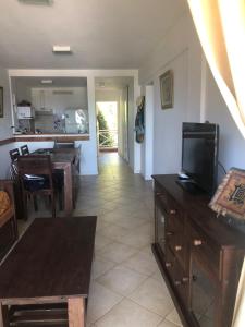 Una sala de estar con televisión y un comedor. en Complejo Playa Palace The Residence, en Costa del Este 44 fotos más