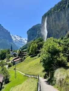 uma cascata numa montanha com uma estrada em Breathtaking Waterfall Apartment nr 3 em Lauterbrunnen