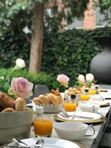 une longue table avec des assiettes de nourriture et de jus d'orange dans l'établissement Boutique Hotel Straelman, à Nimègue