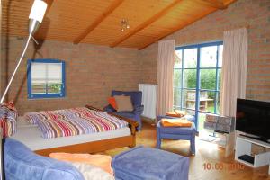 a living room with a bed and a tv at Blankenese in Ahlbeck