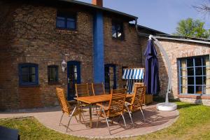 a wooden table and chairs in front of a brick building at Blankenese in Ahlbeck