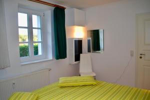 ein Schlafzimmer mit einem Bett, einem Fenster und grünen Vorhängen in der Unterkunft Vineta App. 01 in Bansin