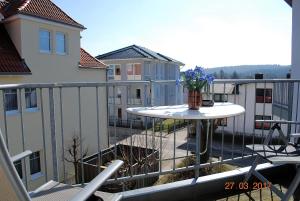 a balcony with a table and a vase of flowers at Wilhelmstr-10-Whg-25 in Ahlbeck