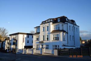 a large white building on the side of a street at Hamburg-App-09 in Ahlbeck