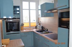 a blue kitchen with a sink and a microwave at Hamburg-App-04 in Ahlbeck