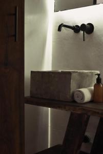 a bathroom with a sink and a towel on a shelf at Amor Rooms in Tulum