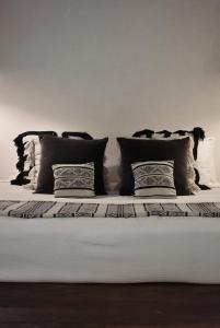 a bed with four pillows on top of it at Amor Rooms in Tulum