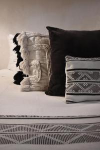 a bed with black and white pillows on it at Amor Rooms in Tulum