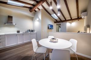 cocina y comedor con mesa blanca y sillas en Garibaldi Luxury apartments, en Prato