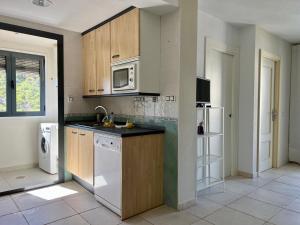 a kitchen with wooden cabinets and a white dishwasher at Aura Apartment Benidorm in Benidorm