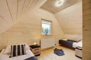 um quarto com duas camas num chalé de madeira em Domek Całoroczny Tylicz em Tylicz