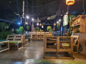 a restaurant with wooden benches and tables and plants at Santiago Dc Hostal in Cali