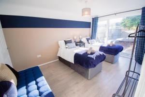 a bedroom with two beds and a couch at Ideal Home Away in Whitefield Bury in Manchester