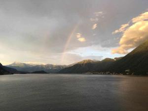 ein Regenbogen über einem großen Wasserkörper mit Bergen in der Unterkunft Villa Peroni Lake Como Vintage in Argegno