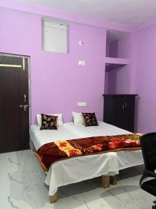 ein Schlafzimmer mit lila Wänden und einem großen Bett in der Unterkunft Riru girlstay in Patna