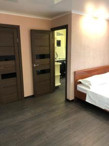 a bedroom with two doors and a bed and a bathroom at Квартира ЛЮКС in Balqash