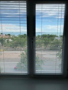 two windows with blinds on them in a room at Квартира ЛЮКС in Balqash