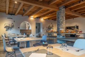 un restaurante con techos de madera, mesas y sillas en Hotel Mon Émile en Aosta
