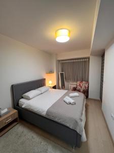 1 dormitorio con 1 cama con 2 toallas en Modern Flatiron Apartment, Skopje Center, en Skopje