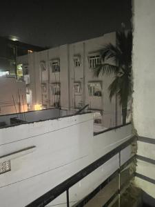 a view of a building at night with a palm tree at Riru girlstay in Patna