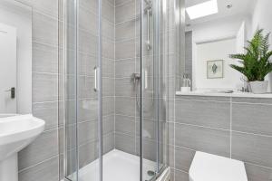 uma casa de banho com um chuveiro, um WC e um lavatório. em Seaview Suite at The Corbyn Apartments em Torquay