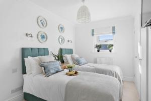 Duas camas num quarto com paredes brancas em Seaview Suite at The Corbyn Apartments em Torquay