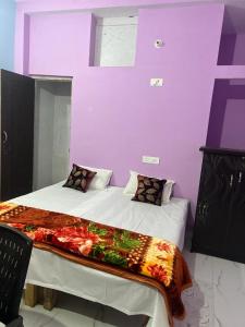 a bedroom with a large bed with purple walls at Riru girlstay in Patna