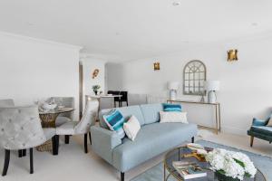 a living room with a blue couch and chairs at The Seaview Suites and Ground Floor Suite at The Corbyn Apartments in Torquay