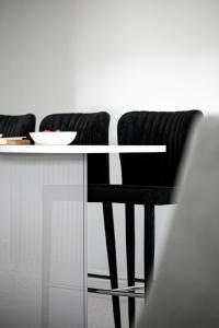 a table with two black chairs and a bowl on it at The Seaview Suites and Ground Floor Suite at The Corbyn Apartments in Torquay