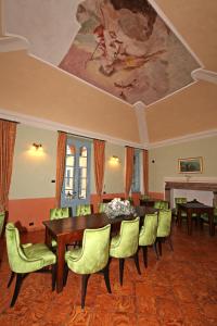una sala da pranzo con tavolo, sedie e un dipinto di Palazzo Del Vicerè a Lezzeno
