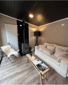 a living room with a bed and a stove at Cabañas de Montaña Armonías Lodge in Los Molles