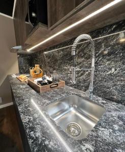 a kitchen counter with a sink and a faucet at Cabañas de Montaña Armonías Lodge in Los Molles